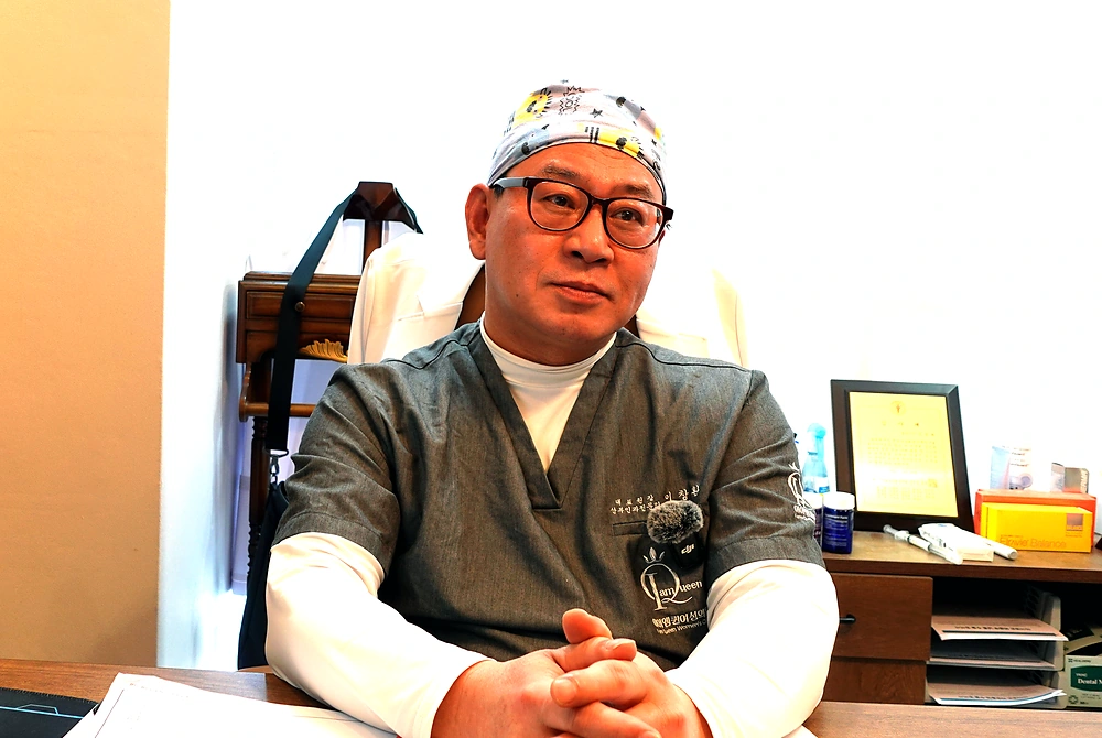 I AM QUEEN WOMEN'S CLINIC代表院長のイ・チャンファン氏が、診察室で婦人科形成について説明している。