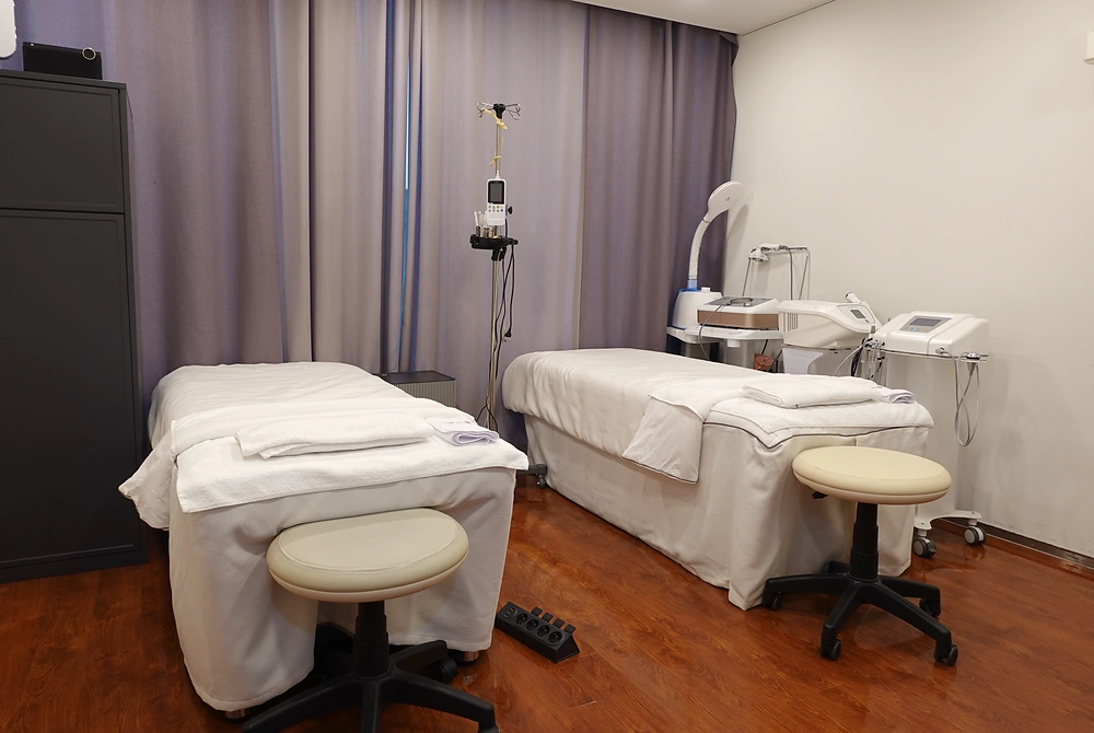 Bonita Clinicの施術室に並ぶ2台のベッドと美容医療機器。