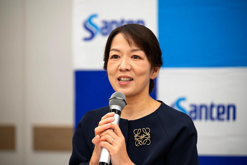 マイクを持ち、後天性眼瞼下垂の診断や点眼治療薬について説明する田邉美香氏。