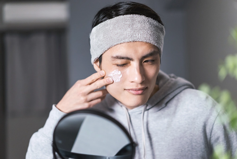 あごに手を添えて肌の状態を確認する男性の口元。