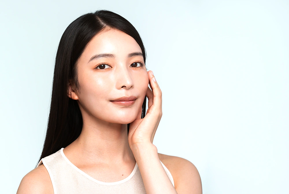 頬に手を添え、顔の中央部が見える女性のポートレート。