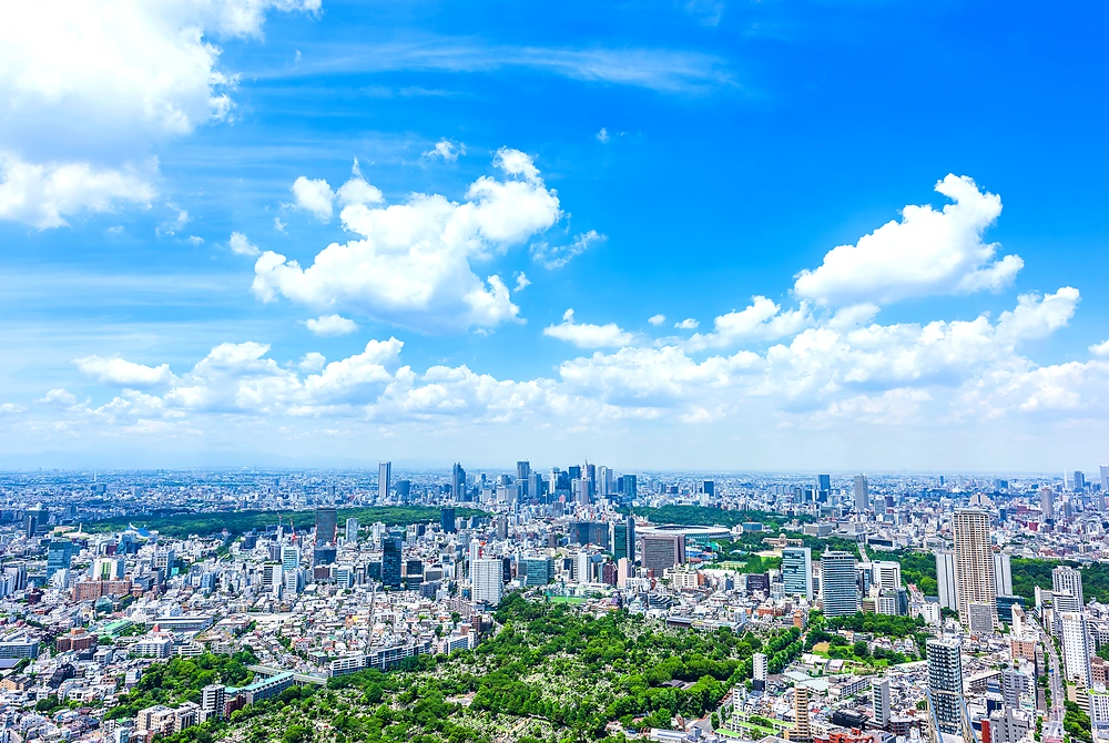 青空の下に広がる東京都心の街並みと緑地。