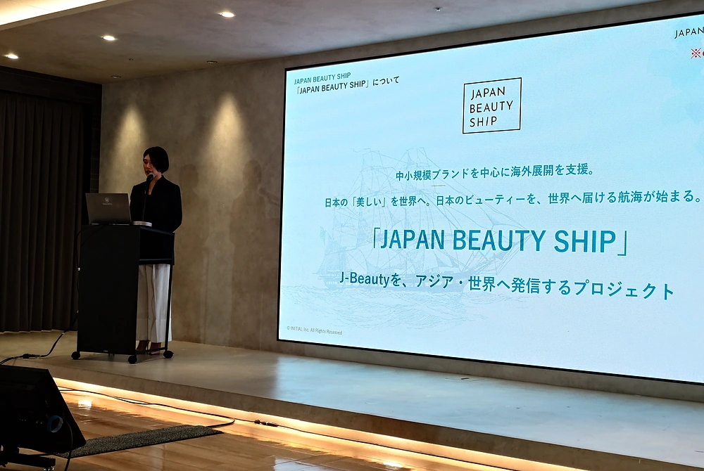 「JAPAN BEAUTY SHIP」の発足発表会で、登壇者がプロジェクトの概要を説明している。スクリーンには中小規模ブランドの海外展開支援について表示されている。