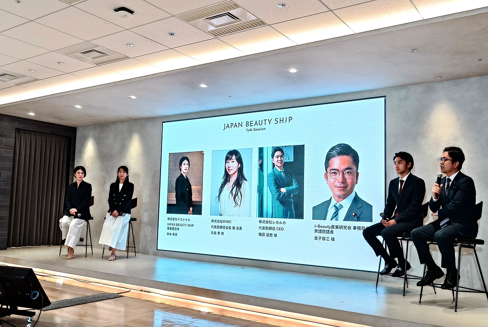日本の美容ブランドの海外進出を支援する「JAPAN BEAUTY SHIP」の発足発表会。4人の登壇者によるトークセッションが行われ、スクリーンには登壇者の氏名と役職が表示されている。