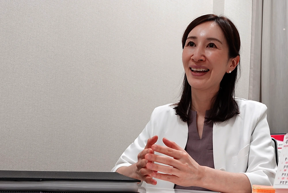 スワンクリニック銀座院長の福澤見菜子氏。白衣を着て、両手を組みながら婦人科形成についてインタビューに答えている。