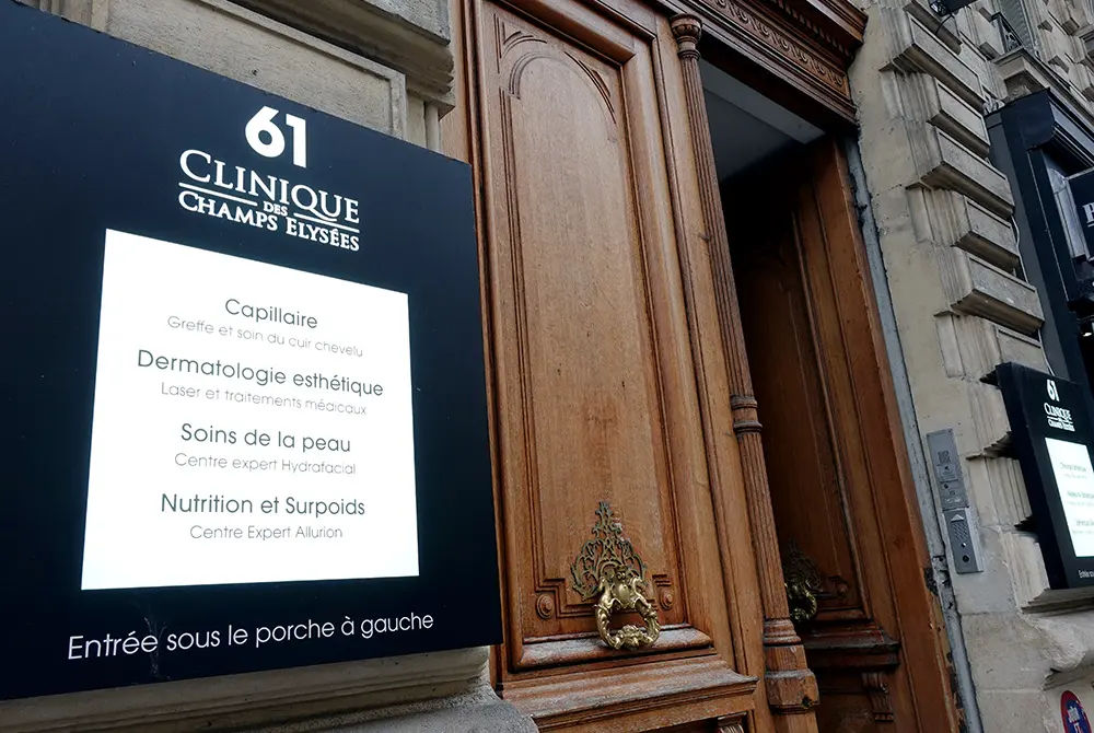 「Clinique des Champs-Élysées」の入口案内板と建物の扉。