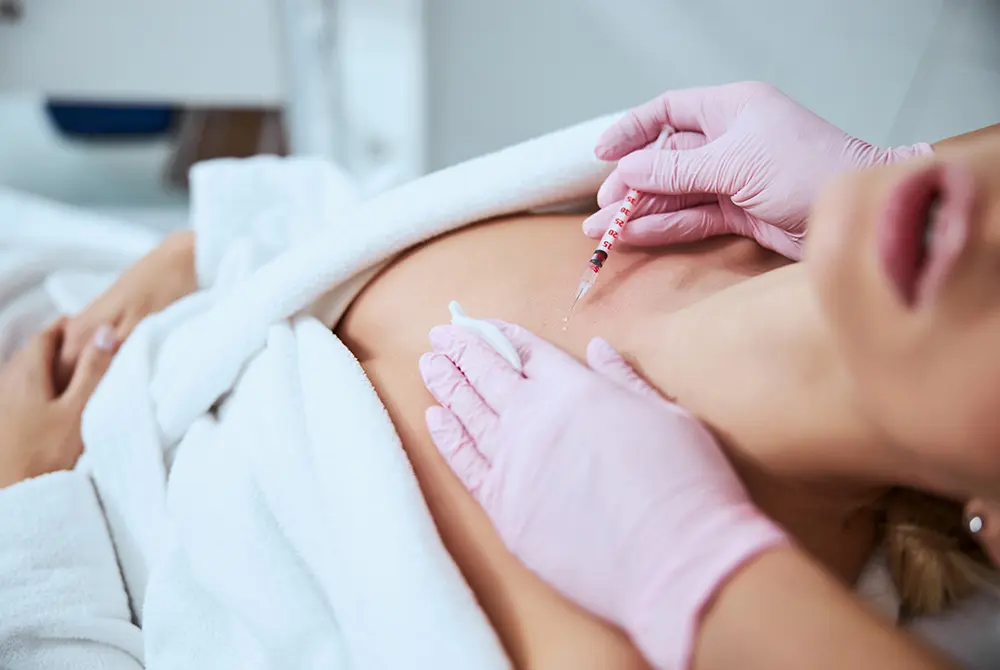 医療機関で首元に注射を行う施術の様子。画像はイメージ。（写真：Adobe Stock）