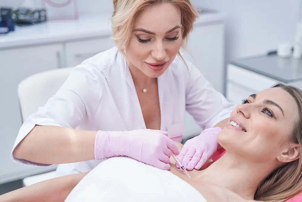 医療従事者が患者とコミュニケーションを取りながら注射を行う様子。画像はイメージ。（写真：Adobe Stock）